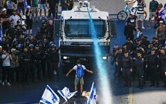 A person stands in front of an Israeli police water cannon being used to disperse demonstrators blocking a road during a protest against plans by Prime Minister Benjamin Netanyahu's government to overhaul the judicial system, in Jerusalem, Monday, July 24, 2023. (AP Photo/Ariel Schalit) A person stands in front of an Israeli police water cannon being used to disperse demonstrators blocking a road during a protest against plans by Prime Minister Benjamin Netanyahu's government to overhaul the judicial system, in Jerusalem, Monday, July 24, 2023. (AP Photo/Ariel Schalit)