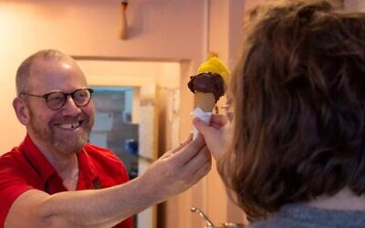 Avi Berg helps a customer in his Cafe Dodo in Berlin. (Courtesy of Berg)
