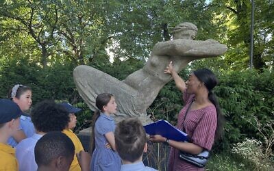 A teacher shows her students Dr Karen Vogel's 1958 statue 'Leaning Woman', which now needs urgent restoration
