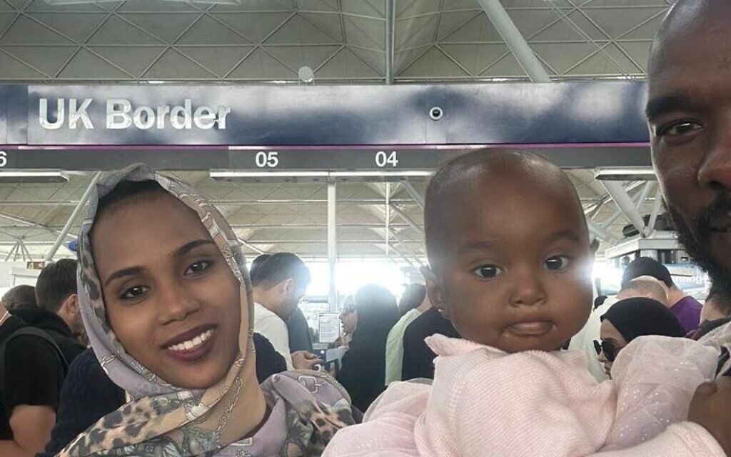 They're home! Salih Adam with his wife and child at Heathrow on Thursday.