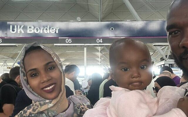 They're home! Salih Adam with his wife and child at Heathrow on Thursday.