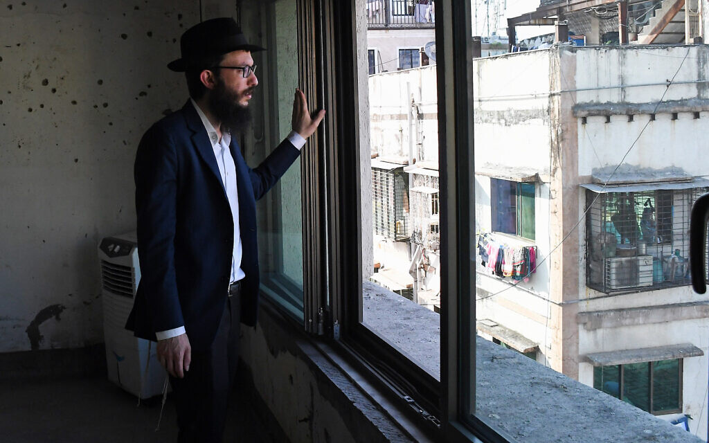 Rabbi Israel Kozlovsky, director of Mumbai's Chabad center, looks out of a window of the center, in front of a wall pock-marked with bullet holes from the 2008 terror attack. (Ashish Vaishnav/SOPA Images/LightRocket via Getty Images)