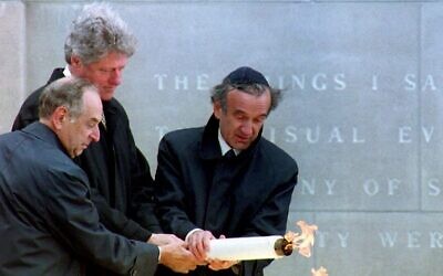 U.S. President Bill Clinton, center, lights the eternal flame at the dedication of the United States Holocaust Memorial Museum with help from Memorial Council chairman Harvey Meyerhoff, left, and founding chairman Elie Wiesel, April 22, 1993. (Renaud Giroux/AFP via Getty Images)