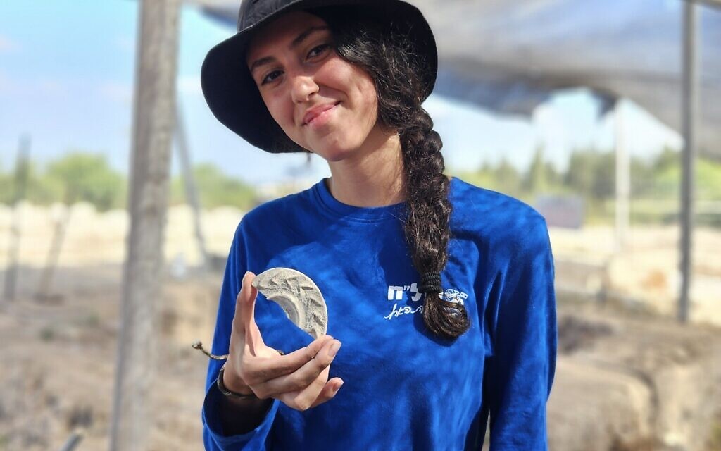 Youth leader Aviv Weitzman holding the magical mirror plaque she discovered at
Usha. Photo: Emil Aladjem, Israel Antiquities Authority