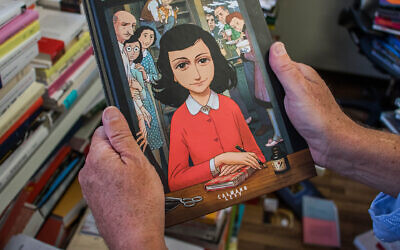 A man holds a copy of the graphic novel version of "The Diary of Anne Frank", by Israeli writer-director Ari Folman and illustrator David Polonsky, in Paris Sept. 18, 2017. (Stringer/AFP via Getty Images)
