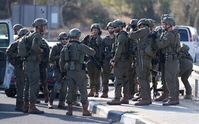 Israeli soldiers gather on the road in central Israel Israel on Saturday, Oct. 7, 2023. . (AP Photo/Ohad Zwigenberg)