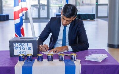 Prime Minister Rishi Sunak signing messages and prayers for Israel during a visit to a school in north London.