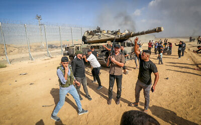 Palestinians take control of an Israeli tank after crossing the border fence with Israel from Khan Yunis in the southern Gaza Strip, October 7, 2023. Photo by Abed Rahim Khatib/Flash90 *** Local Caption *** עזה
טאנק
טנק
חרבות ברזל
גדר
גבול