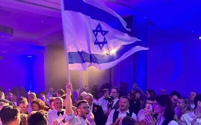 Josh waves the Israeli flag at his wedding. Photo: Sacha Johnstone