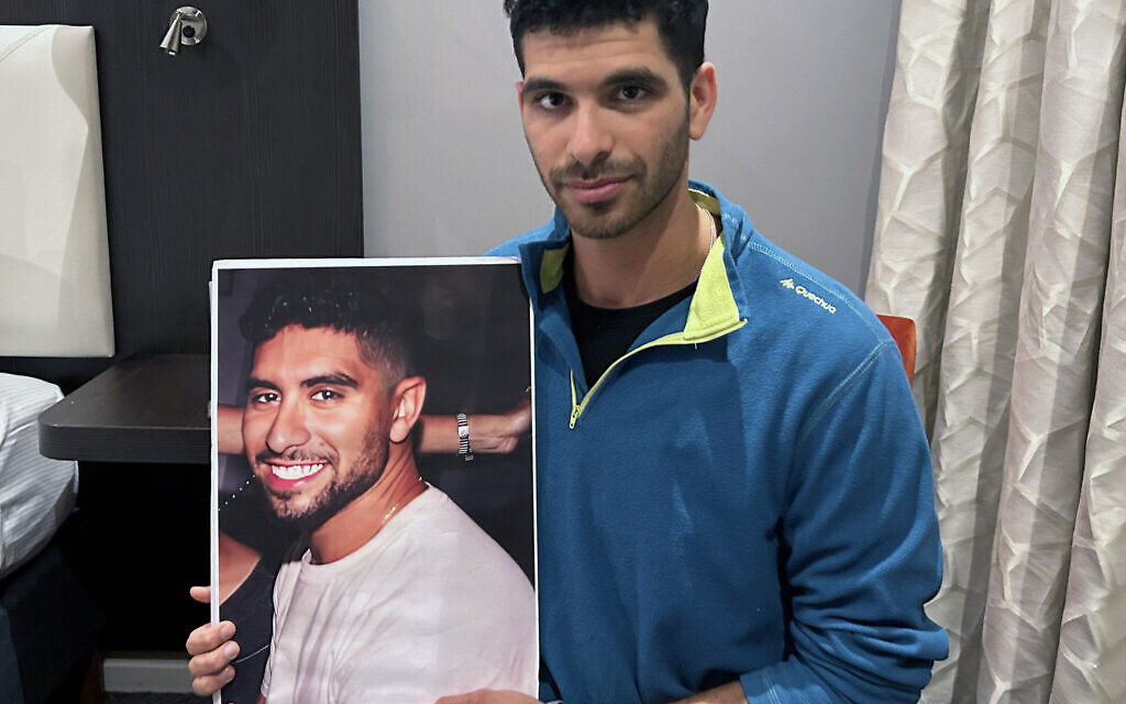 Ilay David, 26, at the DoubleTree by Hilton London hotel, holding a poster of his brother Evyatar David, 22, who was taken hostage by Hamas.