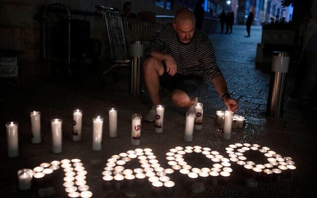 A man lights candles during a vigil marking 30 days since the Oct. 7 Hamas attack.