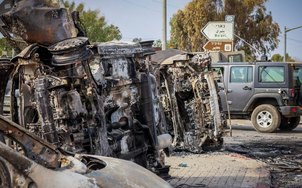 Israeli security seen next to burnt cars at the entrance to Kibbutz Be'eri, near the Israeli-Gaza Border, in southern Israel, Oct. 9, 2023. (Yossi Zamir/Flash90) רחבות ברזל