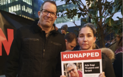 Noam Sagi with a rally participant holding a poster of his mother, Ada, during the seven weeks of fighting for her release. Photograph: Beatrice Sayers