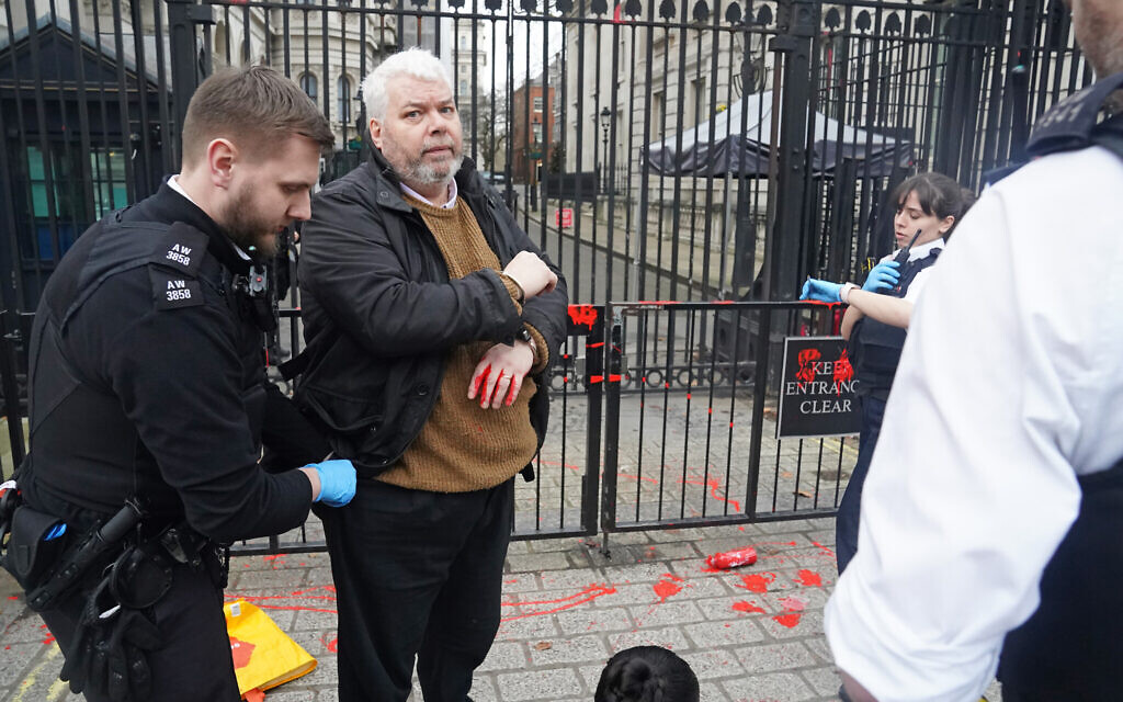 Police officers detain a person outside Downing Street in London, following a protest calling for a ceasefire in the conflict between Israel and Hamas.