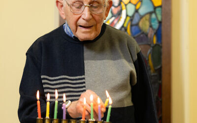 Holocaust Survivor Harry Olmer lighting the Chanukah Candles