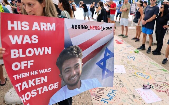 A protester holds a poster with a photo of 23-year-old U.S.-Israeli Hersh Goldberg-Polin as people gather with signs calling for the release of hostages held by Hamas since Oct. 7, during a rally in Tel Aviv.
