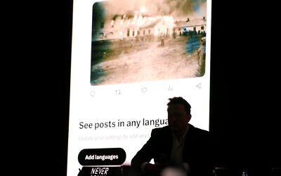 Elon Musk, CEO of Tesla and owner of X (formerly Twitter), sits in front of a video simulating an X feed during the Holocaust during a European Jewish Association conference in Krakow, Poland, Jan. 22, 2024. (Klaudia Radecka/NurPhoto via Getty Images via JTA)
