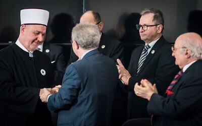 The grand mufti of Bosnia, Husein ef. Kavazović, shakes hands with Menachem Rosensaft, who was born in a displaced persons camp, at a ceremony marking the launch of a new peace initiative in Srebrenica, Bosnia, Jan. 28, 2024. (Courtesy Srebrenica Memorial Center)