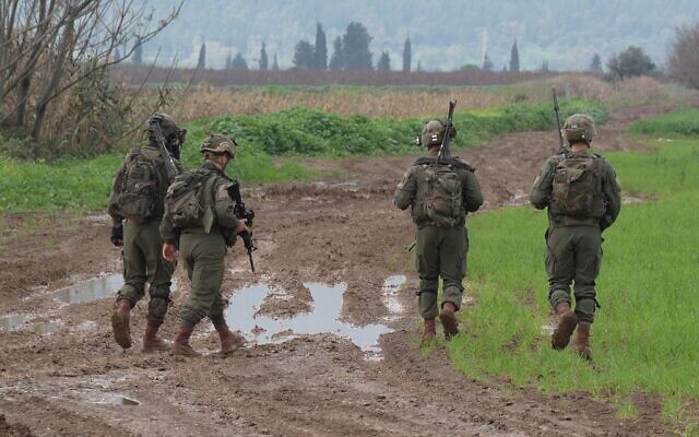 Israeli soldiers search a field after two explosive-laden drones were reportedly used by Hezbollah militants to launch an aerial assault against an Israeli air defense system site near Kibbutz Blum close to the border with Lebanon on January 25, 2024 in Kfar Blum, Israel.