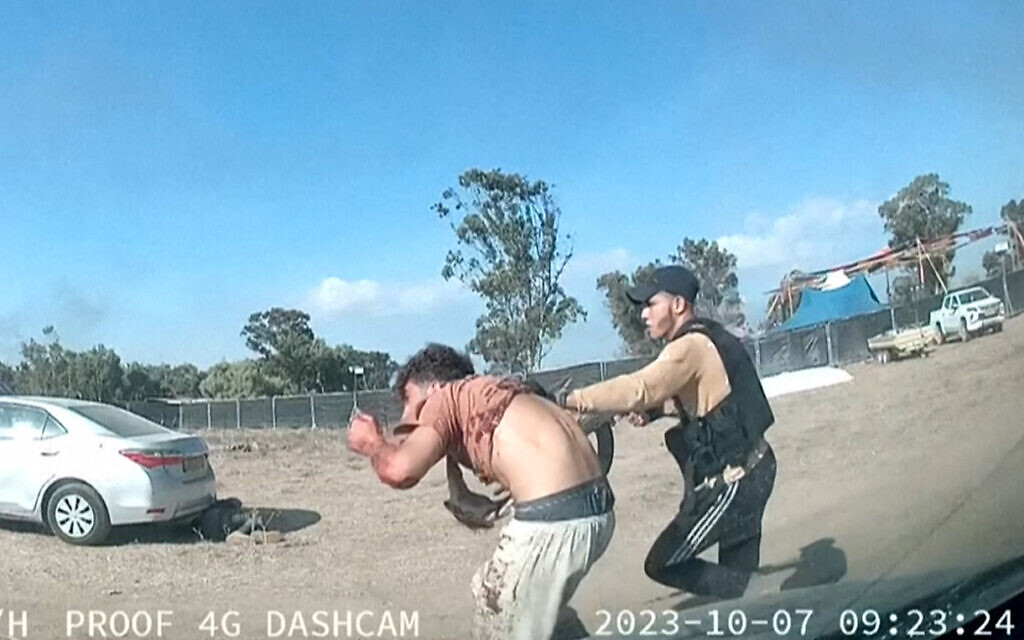 Dashcam photo of a Hamas terrorist capturing a man at the Supernova music festival, held near Kibbutz Reim in Israel's southern Negev desert on October 7 2023, where terrorists from Gaza killed hundreds of individuals.