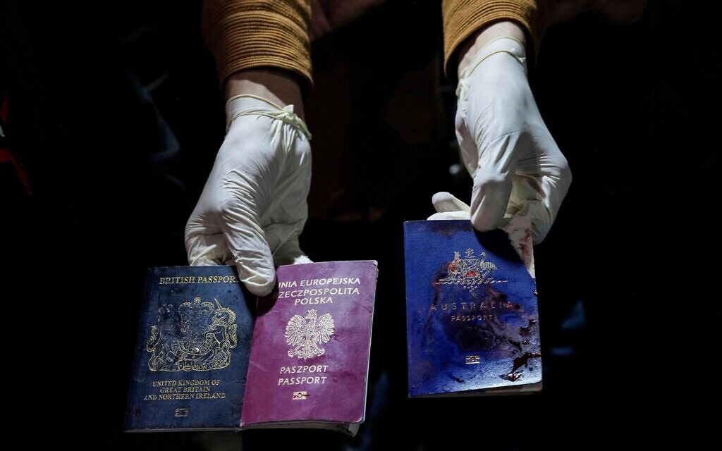 A man displays blood-stained British, Polish, and Australian passports after an Israeli airstrike, in Deir al-Balah, Gaza Strip