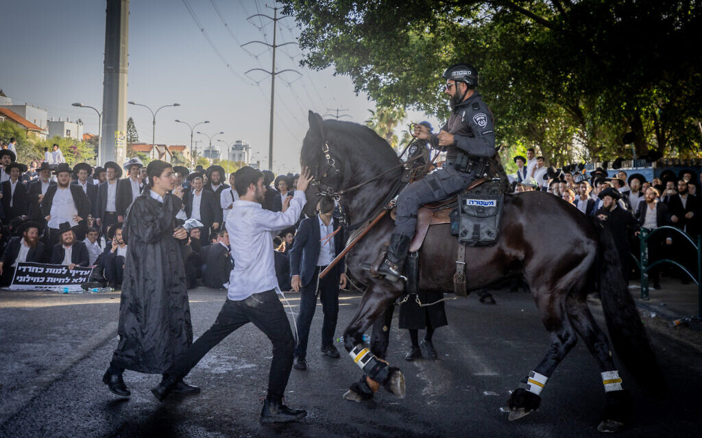 Ultra orthodox Jews block a road and clash with police during a protest against the drafting of Ultra orthodox jews to the Israeli army, on road number 4, outside the city of Bnei Brak, April 1, 2024. Photo by Chaim Goldberg/Flash90