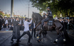 Ultra orthodox Jews block a road and clash with police during a protest against the drafting of Ultra orthodox jews to the Israeli army, on road number 4, outside the city of Bnei Brak, April 1, 2024. Photo by Chaim Goldberg/Flash90