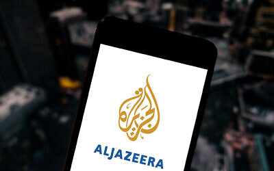 In this photo illustration the Al Jazeera logo is seen displayed on a smartphone.