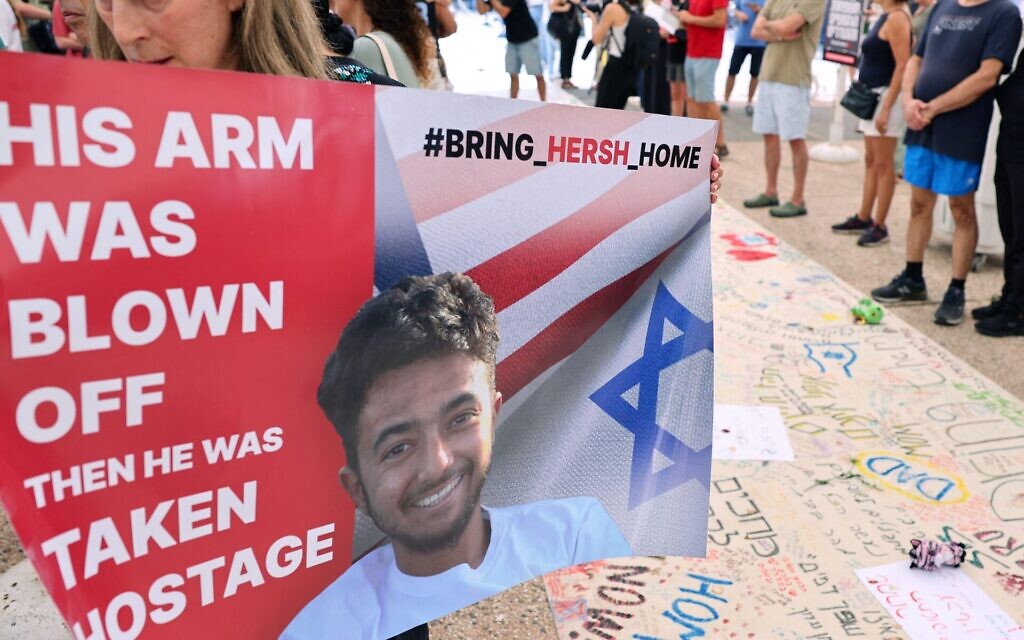 A protester holds a poster with a photo of 23-year-old U.S.-Israeli Hersh Goldberg-Polin as people gather with signs calling for the release of hostages held by Hamas since Oct. 7, during a rally in Tel Aviv, October 28, 2023. (Jack Guez/AFP via Getty Images)