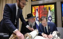 Israeli President Isaac Herzog writes the final letter to in a Torah initiated by Ukraine's president Volodymyr Zelensky, April 2024 in Jerusalem. (Courtesy Israeli president's office)