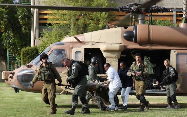 Israeli army rescue medics and a hospital worker stretcher a wounded Israeli soldier from a helicopter.