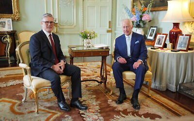 King Charles III sits with Sir Keir Starmer during an audience at Buckingham Palace,