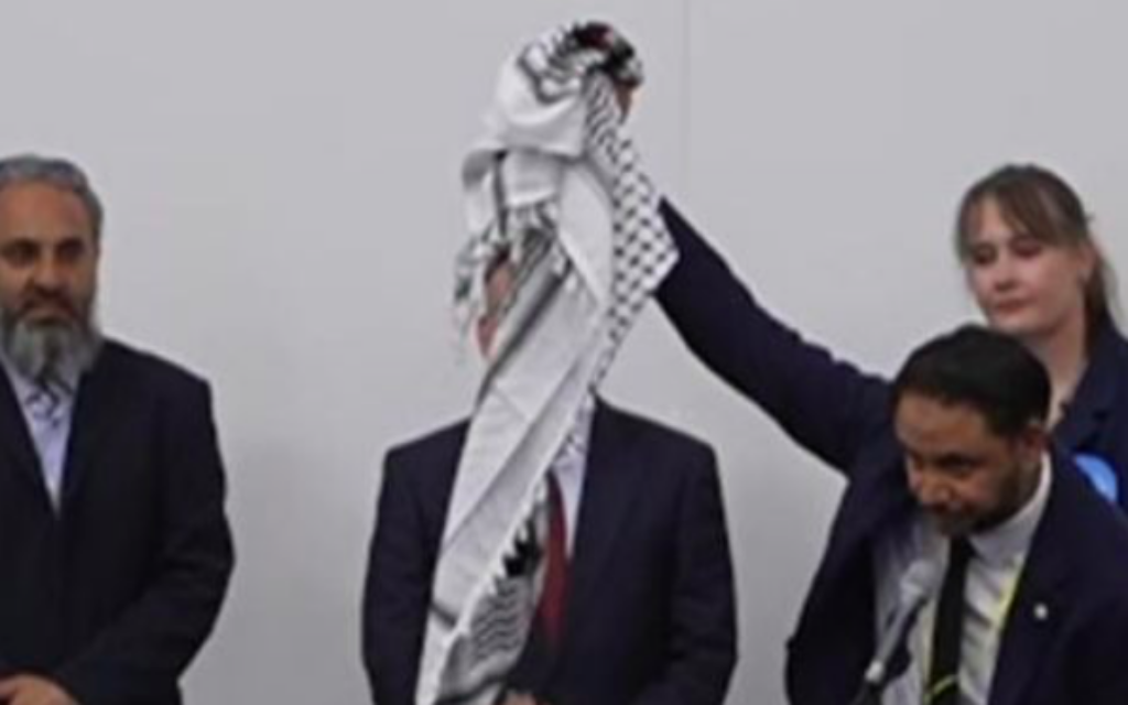Shockat Adam lifts Palestinian Keffiyah after his Leicester South election victory is confirmed