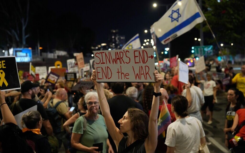 A demonstrator holds a sign about the killing of Hamas leader Yahya Sinwar during a protest calling for a ceasefire deal and the immediate release of hostages held by Hamas on Thursday