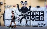 People pass by a newly painted graffiti depicting Hamas Leader Yahya Sinwar, days after he was killed by Israeli forces in Gaza