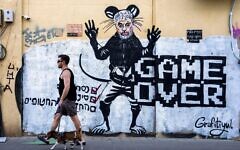 People pass by a newly painted graffiti depicting Hamas Leader Yahya Sinwar, days after he was killed by Israeli forces in Gaza