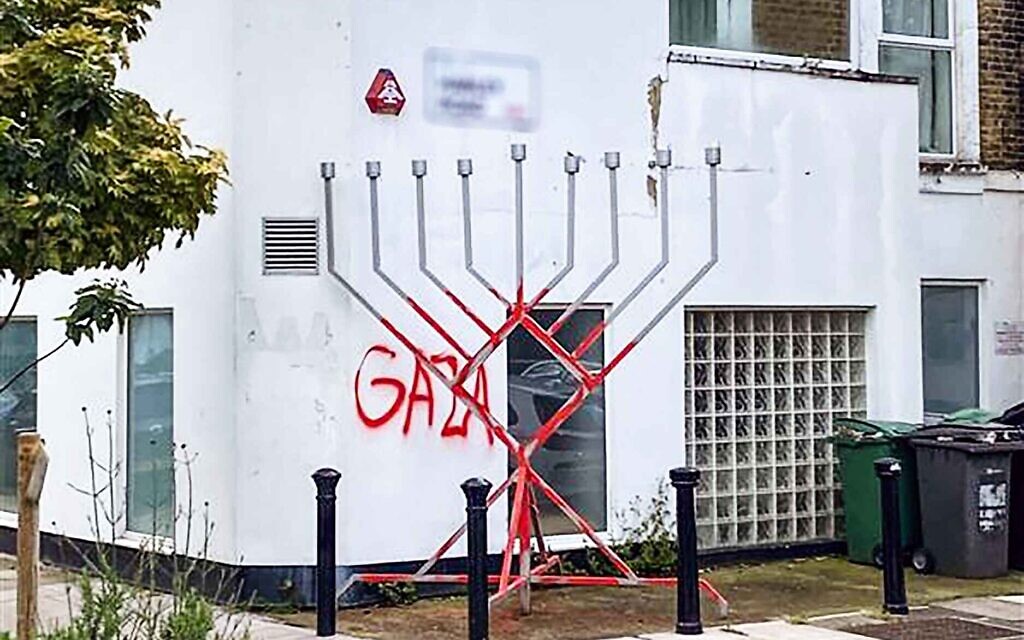 A menorah defaced and “GAZA” daubed on adjacent wall in London, May