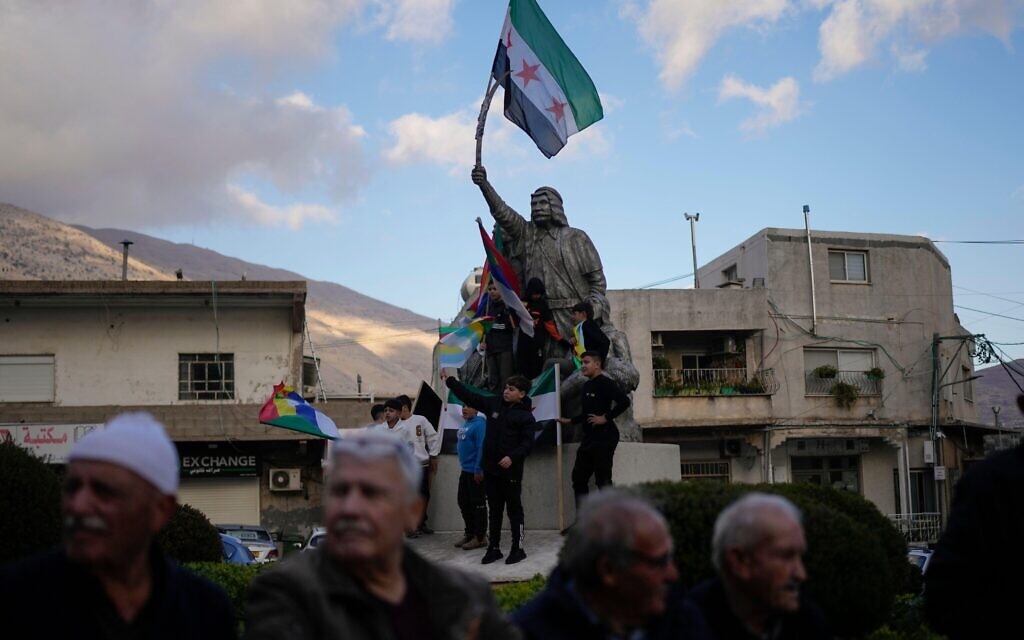 People attend a rally celebrating the fall of Syrian President Bashar Assad's government, in the town of Majdal Shams, in the Israeli-annexed Golan Heights, Sunday, Dec. 8, 2024. (AP Photo/Matias Delacroix)