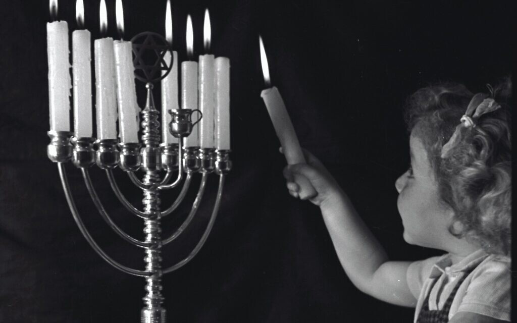 A Jerusalem girl, representing the young generation of Jewish life in Eretz Israel, lights a Chanukah Menorah as a symbol of the revival of light. Jerusalem, 1947. Credit KKL-JNF Photo Archive A Jerusalem girl, representing the young generation of Jewish life in Eretz Israel, lights a Chanukah Menorah as a symbol of the revival of light. Jerusalem, 1947. Credit KKL-JNF Photo Archive