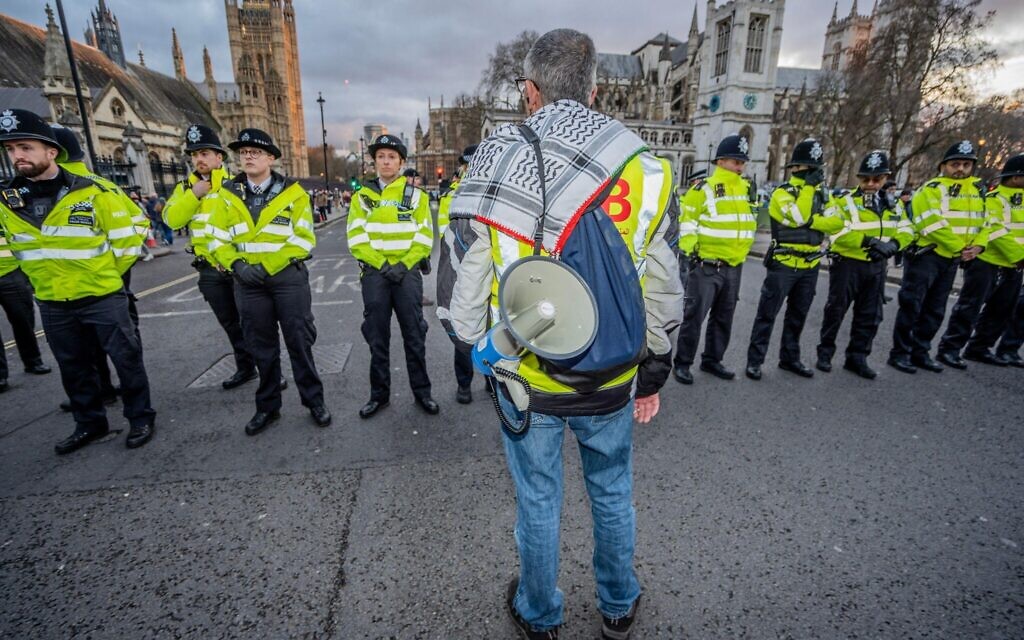 Polic form a human cordon to separate the pro-Palestine demonstrators from pro-Israel counter-protestors.