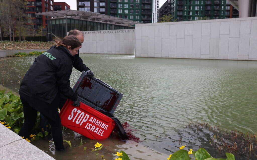 Greenpeace activists pour red dye into the US embassy pond in London during a protest against arms sales to Israel