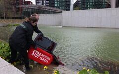 Greenpeace activists pour red dye into the US embassy pond in London during a protest against arms sales to Israel