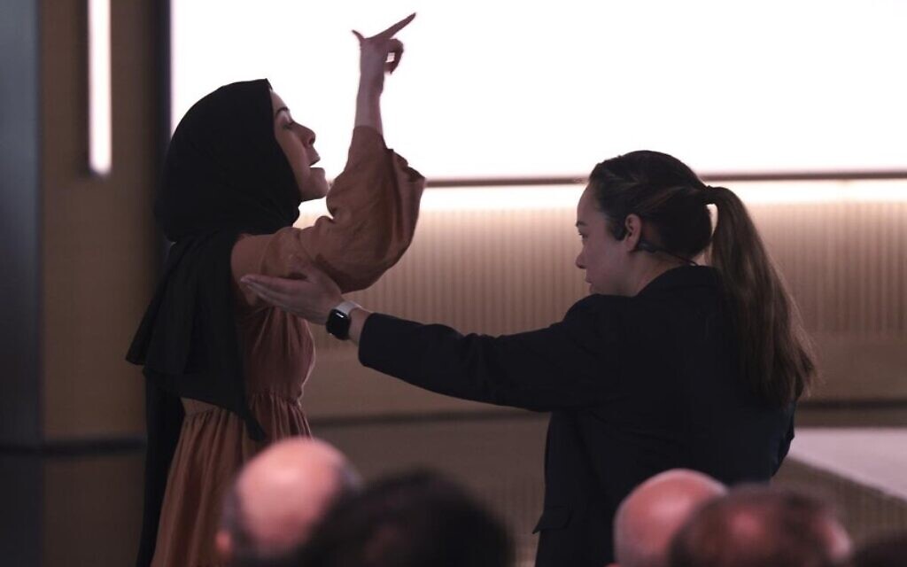 Ibtihal Aboussad is removed by security after interrupting Microsoft’s AI chief during a protest. Photo taken from X