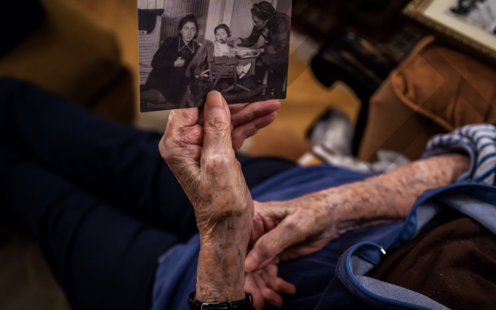 A Holocaust survivor in Hungary displays photos of her family. Photo: Marton Monus/Claims Conference