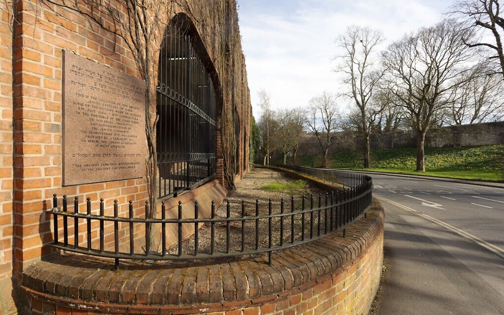 General view along the south-west wall of the Fossbank Car Park, showing the Jewbury Cemetery Plaque in the foreground, commemorating the site of the medieval Jewish cemetery of York. © Historic England Archive-