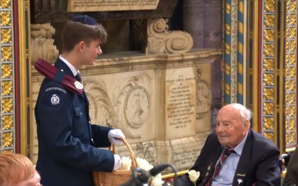 Sam Rose-Isaacs, wearing his JLGB uniform and kippah, distributes white roses to veterans during the VE Day 80 service at Westminster Abbey. Photo Credit: BBC