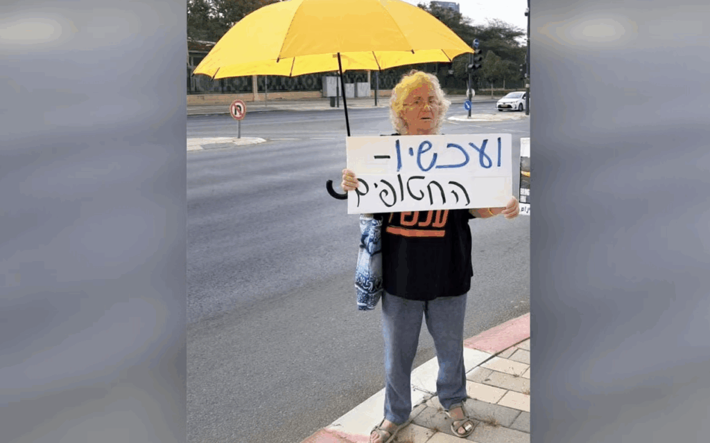 Naomi Shaanan, killed when an Iranian missile struck her apartment building in Beersheba on 24 June, 2025, holds a sign in Hebrew that reads, “And now — the hostages.” (Via X)