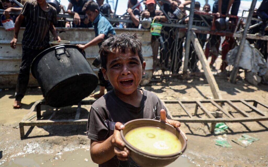 24th July, 2025. A Palestinian child receives food in Gaza City, on July 24, 2025.