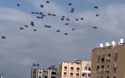 Aid airdrops descend over northern Gaza as buildings lie in ruins below. Screenshot/X