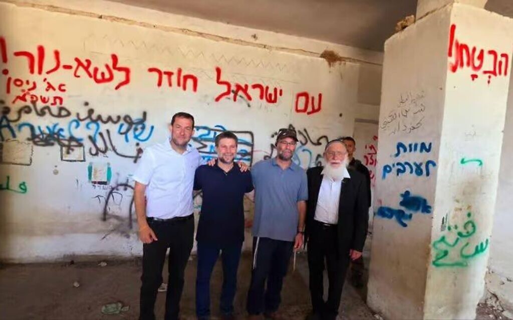 Finance Minister Smotrich (second from left) pictured at Sa-Nur beside graffiti reading "Death to Arabs" (Photo Credit: X)
